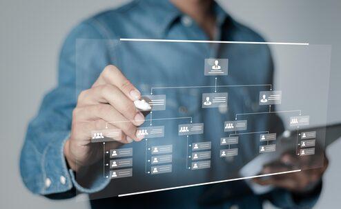 Organisationsentwicklung Person steht vor virtueller Pinnwand und erstellt Organigramm.